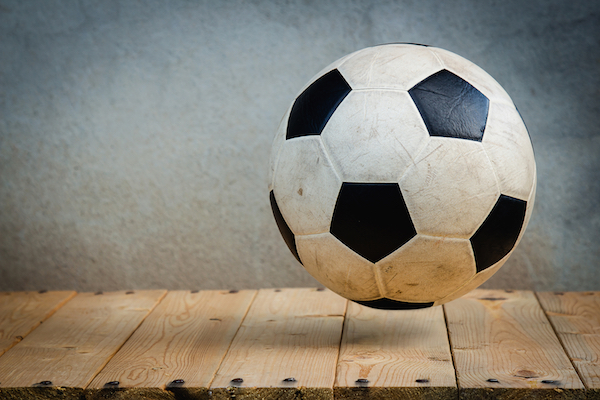 soccer ball bouncing on a wooden floor, image for ari monkarsh blog about sports in philanthropy